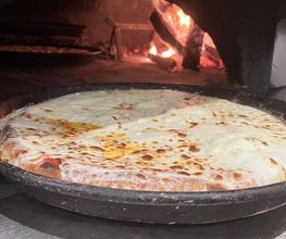 Tegia di pizza margherita in forno a legna