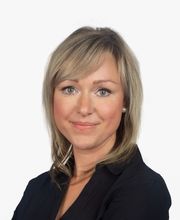 Frau mit hellen Haaren und schwarzem Blazer.