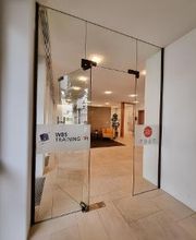 Eingangstür  aus Glas im hellen Eingangsbereich.