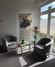 Pausenbereich mit 2 Sesseln vor einem Roll Up Banner. Daneben ein Beistelltisch mit Zimmerpflanze.