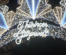 Spektakuläre Lichtinstallation mit goldener Funkenrad-Skulptur und leuchtendem Riesenrad bei der Thüringer Glitzerwelt
