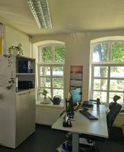 Empfangsbüro mit einem Schreibtisch, einem Stuhl, zwei Monitoren, einer Maus und Tastatur