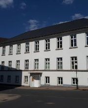 ein weißes Gebäude mit zwei Stockwerken.