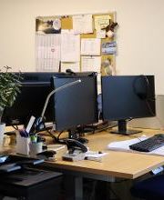 Büro mit 2 Arbeitsplätzen und einer vollen Pinnwand.