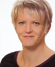 Portrait einer Mitarbeiterin mit kurzen blonden Haaren.