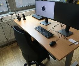 ein PC Arbeitsplatz mit 2 Bildschirmen, einem Bürostuhl, einer Tastatur und einer Maus.
