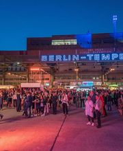 FirstLoveCoffee GmbH - Kaffee Catering Berlin - Mobiles Kaffee Catering bei großem Abend-Event in Berlin Tempelhof mit türkisem Kaffeeanhänger, Barista-Service und vielen Gästen auf einer Outdoor-Veranstaltung.