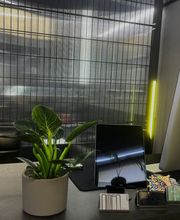 Rezeption im OMEN Tattoo Lab Friedrichshain Berlin. Moderner Empfangsbereich mit Metallgittern, Pflanzen und urbanem Design für Beratung und Walk-ins.