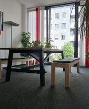 Zwei Sitzbänke an einem Tisch vor einem Fenster