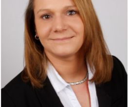 Eine ca. 35 Jahre alte Frau mit braunen halblangen Haaren und einem schwarzen Blazer
