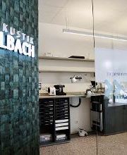 Blick in die Werkstatt, links ein beleuchtetes Vollbach Logo.