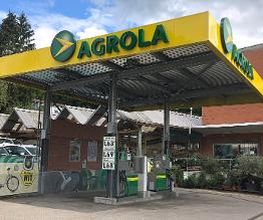 AGROLA Tankstelle in Bolligen; zwei Tanksäulen; im Hintergrund ein rotes Gebäude; links ein Landi-Werbeplakat
