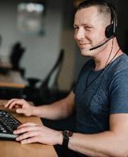 Ein Teilnehmer sitzt an seinem Arbeitsplatz und trägt sein Headset.