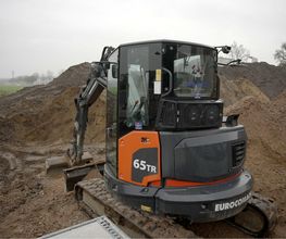 Kompaktbagger beim Aushub für Fundament und Bodenplatte auf einer Baustelle von AS-Bau aus Lage.