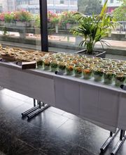 dean&david Catering | Pforzheim - Langes Catering Buffet mit Wraps, Sandwiches und vielen Bowls im Glas vor großer Fensterfront für Empfang, Tagung oder Business Lunch.