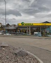 AGROLA Tankstelle in Winznau; im Vordergrund Strasse - Tankstelle mit TopShop; links Totem mit AGROLA Logo und digitaler Preisanzeige