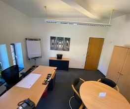 Tagesbüro mit Fenster und Besprechungstisch.