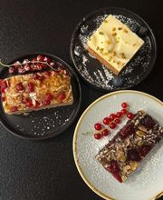 dean&david Catering | Stuttgart - Dekorativ angerichtete Kuchenstücke mit Beeren, Nüssen und Puderzucker als süßes Dessertangebot für Buffet, Empfang oder Kaffeepause.
