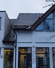 Vorderansicht des Bürogebäudes mit Ladenzeile im Erdgeschoss.