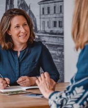 Webstudio Dresden Beratungssituation am Tisch, offene Kommunikation mit Notizen, Fokus auf persönliche und individuelle Betreuung.