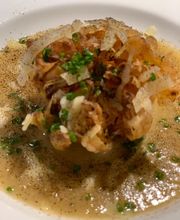 Geschlossene Gesellschaft Nahaufnahme einer edlen Suppe mit knusprigem Topping und frischen Kräutern – Fine Dining bei Geschlossene Gesellschaft von Wulf Mey.