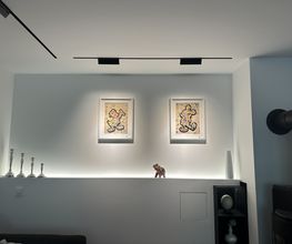 Individuell gestaltete Studio-Ecke im Wohnzimmer mit Q4-Oberflächen, indirekter Beleuchtung und integriertem 48-V-Magnetschienensystem.
