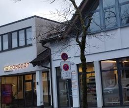 Vorderansicht des Bürogebäudes mit Ladenzeile im Erdgeschoss.