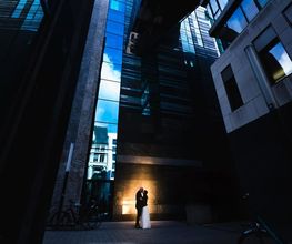 Hochzeitsfotograf Tom Maiwald - Kreatives urbanes Brautpaarshooting zwischen moderner Architektur in Leipzig. Das Paar wird bewusst klein im Bild inszeniert und von Licht, Linien und Gebäuden eingerahmt.