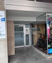 Eingang mit Beschilderung WBS TRAINING, Eingangstür, rechts Fahrradladen.