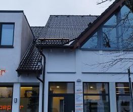 Vorderansicht des Bürogebäudes mit Ladenzeile im Erdgeschoss.