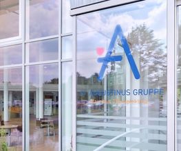 Verglaster Eingangsbereich der Mauritius Therapieklinik mit dem Logo der St. Augustinus Gruppe auf der Eingangstür.
