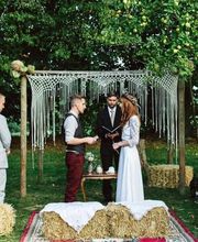 In einem dichten Wald stehen Braut und Bräutigam unter freiem Himmel und feiern ihre Trauung