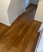 Parkettverlegung durch MC Bodenservice in Braunschweig. Gezeigt wird ein neu verlegter Parkettboden im Flur mit Übergang zum Wohnraum.