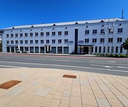 Ein weißes Bürogebäude an einer Straße.