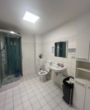 TA WingTsun Linden-Limmer - Modernes Badezimmer mit Dusche, Waschbecken, WC und heller Fliesengestaltung als gepflegte Ausstattung im Trainingsstudio für Mitglieder und Besucher.