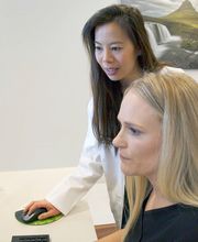 Jennifer Dang, MD, checking something on the computer with a colleague