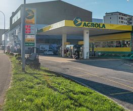 AGROLA Tankstelle in Wittenbach mit LAVEBA Shop. Links im Bild Rasen dahinter Totem mit AGROLA Logo, digitaler Preisanzeige von Treibstoff und LAVEBA Shop Logo. Rechts Tankstelle.