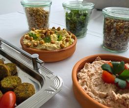 dean&david Catering | Karlsruhe - Frische Falafelplatte mit Hummus, cremigem Dip, Nüssen, Kräutern und Aufstrichen als vielseitige Fingerfood Auswahl für Event Catering.