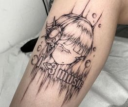 Anime-inspiriertes Tattoo mit Skript am Bein.