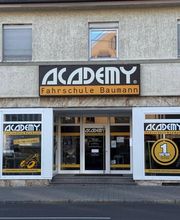 Academy Fahrschule Baumann - Stuttgart Vaihingen - Nahaufnahme des Eingangsbereichs einer Fahrschule in Stuttgart-Vaihingen mit Schaufensterwerbung für Führerschein, Theorieunterricht und praktische Fahrausbildung.