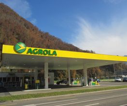 AGROLA Tankstelle in Schattdorf, Uri; überdacht mit TopShop; im Hintergrund Waldhügel