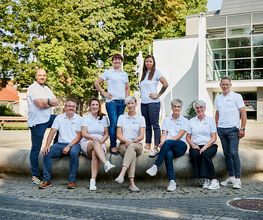 Das Team Region Bautzen-Görlitz, bestehend aus 6 Frauen und 3 Männer posiert auf einem Brunnenrand für ein Foto.