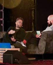 Foto und Filmproduktion Laila Tkotz Bühneninterview mit zwei Experten im Gespräch auf dunkler Bühne