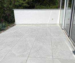 Edle Keramiksteine auf stabiler Betongrundlage und eine frisch verputzte Wand - für eine moderne und gepflegte Terrassengestaltung