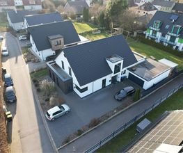 Luftbild eines fertigen Einfamilienhauses mit Garage. AS-Bau baut Einfamilienhäuser auf Wunsch schlüsselfertig.
