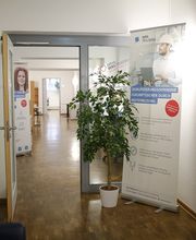 Flur mit Grünpflanze und Werbeaufsteller-