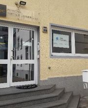 Außenansicht des Gebäudes mit Eingangsbereich. Gelbe Fassade und WBS TRAINING Schild im Fenster. Weißer Briefkasten.