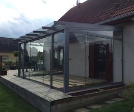 Terrassenüberdachung mit Ganzglasschiebetüren und Dachüberstand