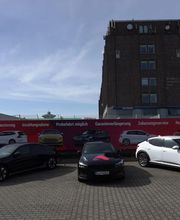 3 Elektrofahrzeuge stehen vor einem Authaus 24 Werbebanner