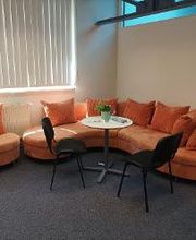 Gemütliche Sitzecke mit einem orangefarbenen Sofa und Tischgruppe.